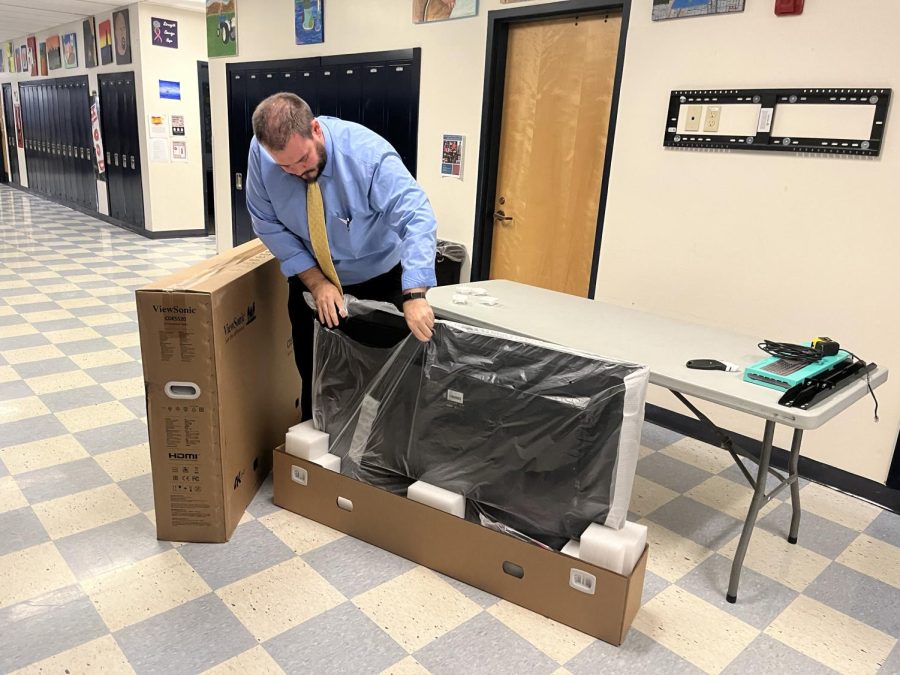 Todd Powers unboxing and preparing one of the new TVs in BMUs hallway.