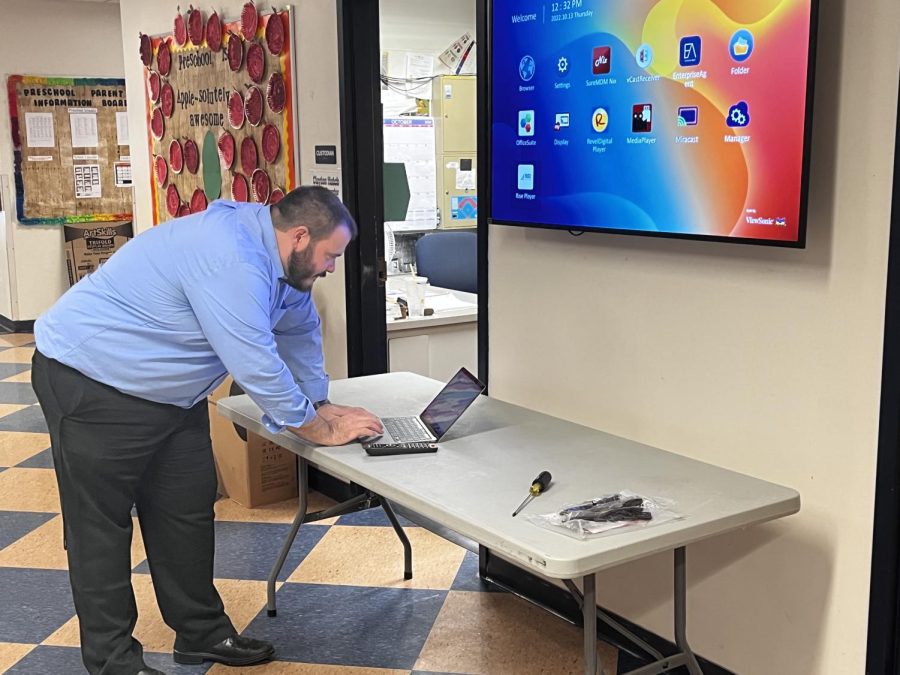 Athletic Director and Systems Administrator Todd Powers sets up TVs for daily updates and BNN News in the hallways on October 13, 2022.