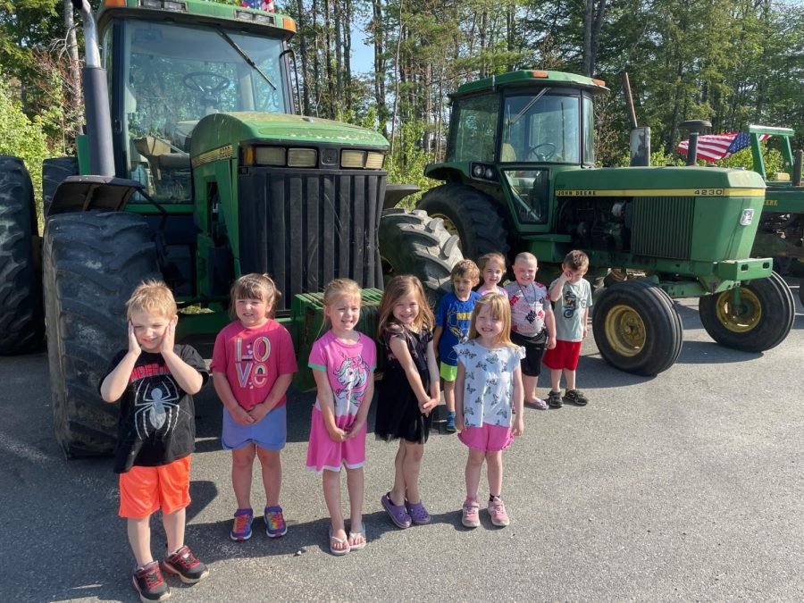 A group of preschoolers seen visiting the line of tractors.