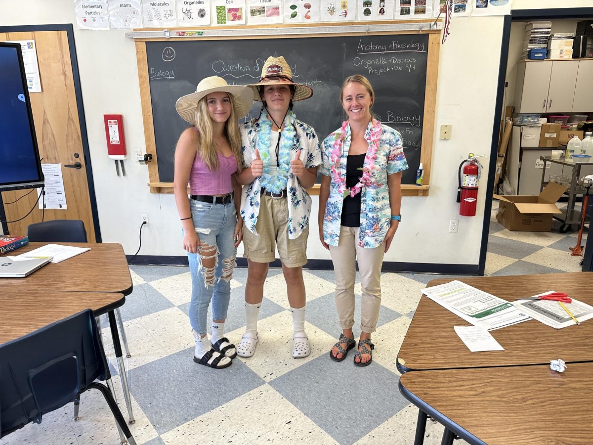 Freshmen+Addison+Murray+and+Ava+Kingsbury+stand+dressed+in+tacky+tourist+outfits+with+high+school+science+teacher+Ms.+DeBois+on+Thursday%2C+September+14th.