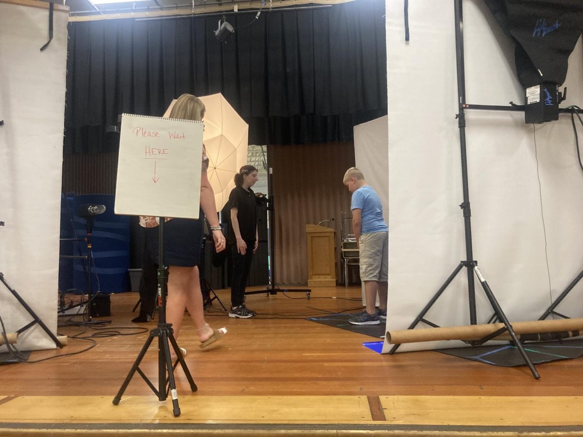 Lifetouch employees are set up and ready to take pictures for this school years BMU picture day. Positioning for his turn in front of the camera is fifth grader Cyles Moore. 