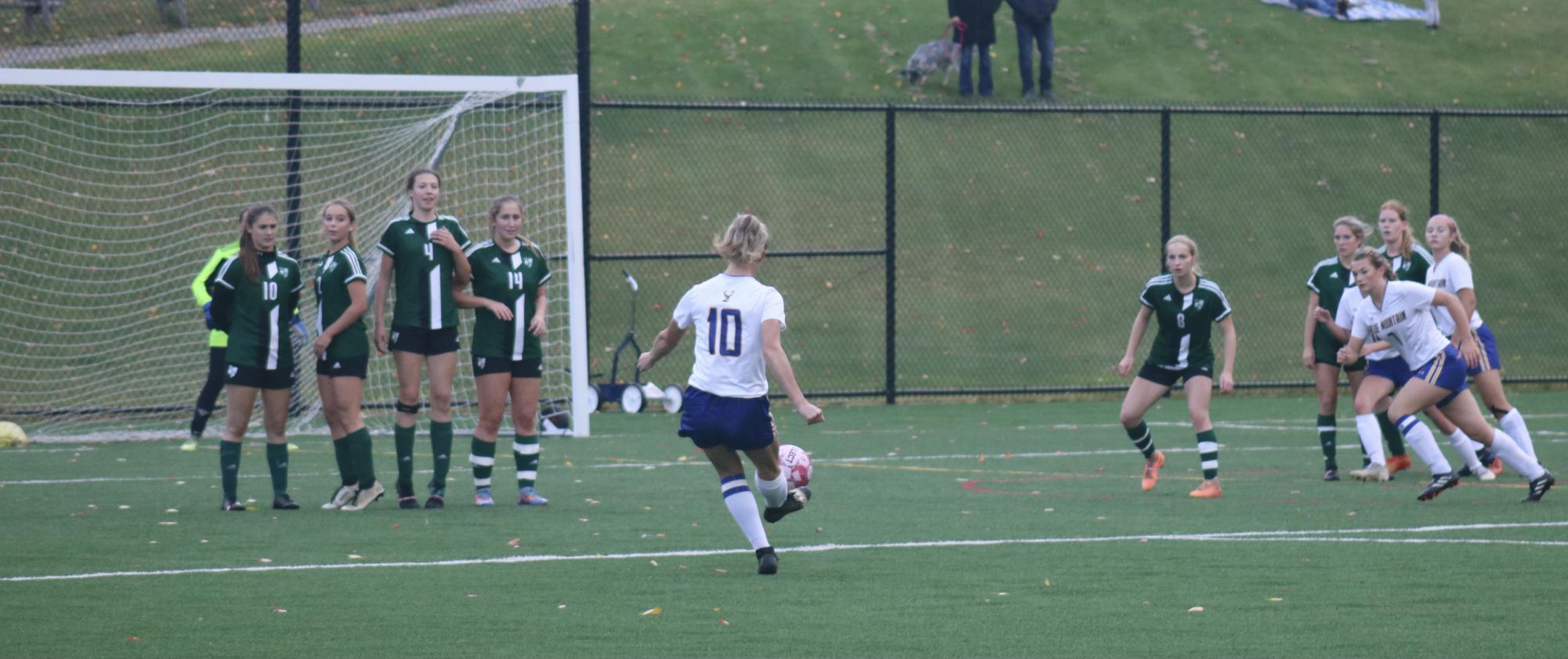 BMU senior Jordan Alley takes a direct kick, and drives it over the Enosburg defenders. 