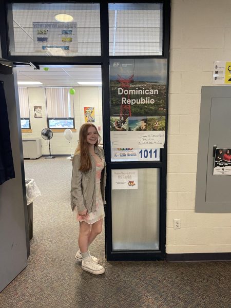 Alexandra Deforqe standing by the Global Explorers poster on January 11, 2024, for the Dominican Republic trip . 