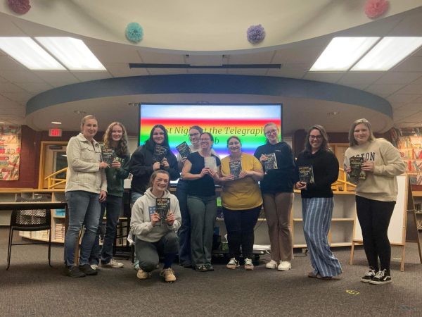 Blue Mountains Gender and Sexuality Alliance pose for a photo after their book discussion in the BMU library on April 16, 2024. Pictured (from left to right) Erin Nelson, Susanna Nelson, Isabel Hand, Karli Blood (kneeling), River Woods, Jennie Lund, Joy Solomon, Bella Craige, Melissa Beaulieu, and Jess Pinette. 