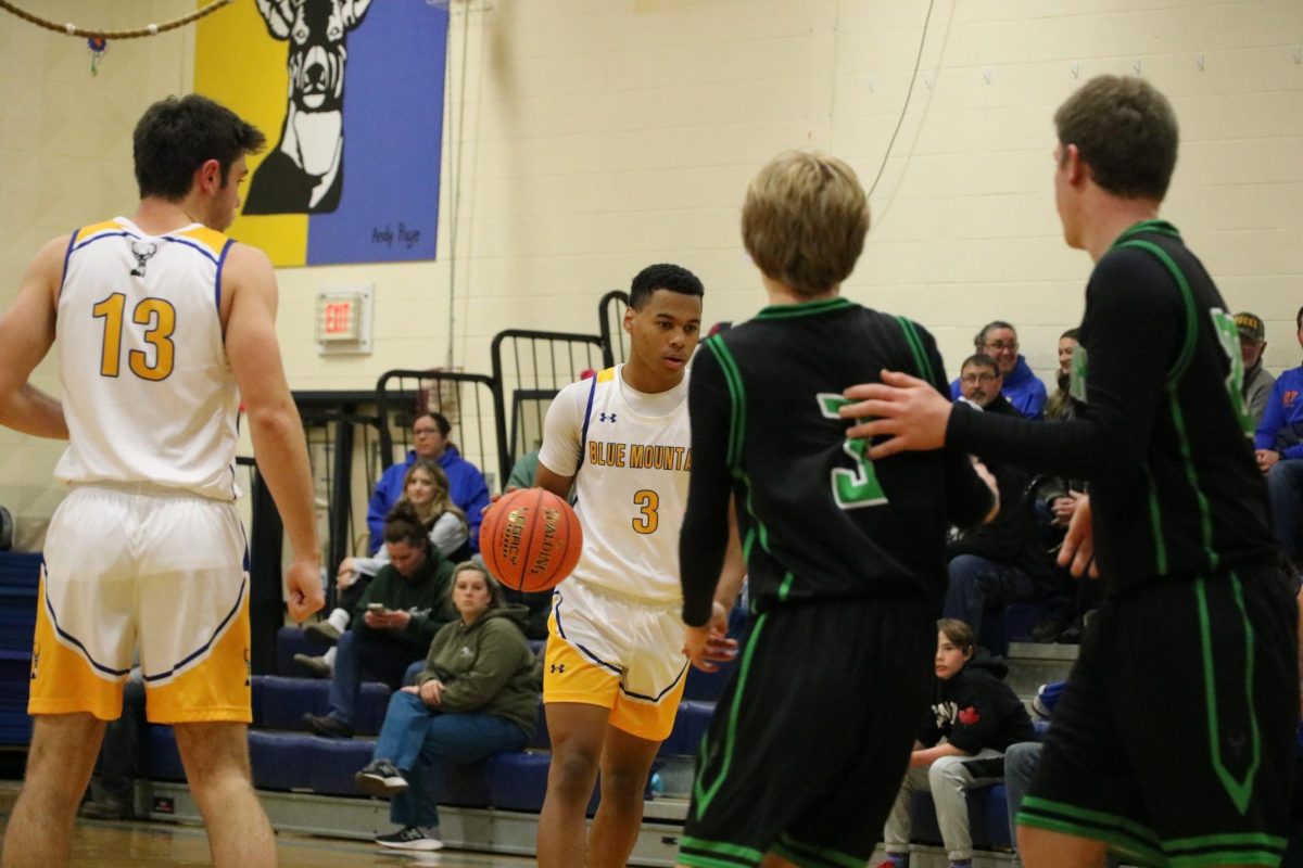 Jamal Saibou approaches the basket with Will Emerson at the top of the Key while the Phoenixes move to defend in the Dr. Harry M. Rowe Gymnasium, Wells River, VT.