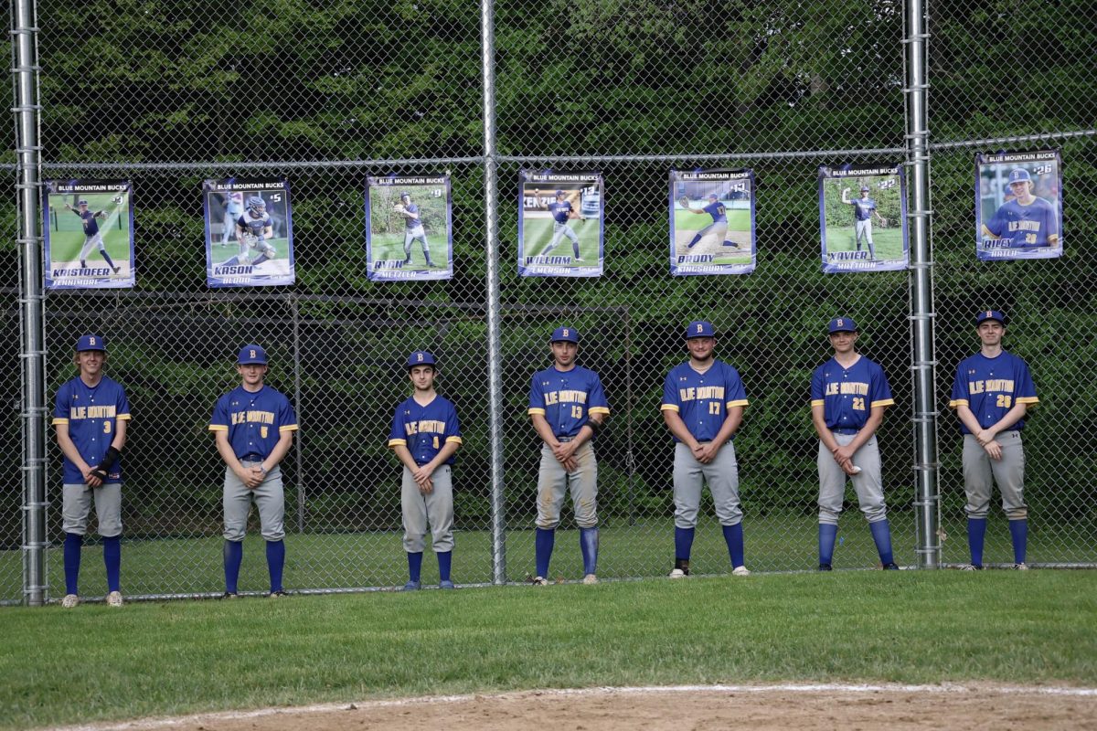 BMU Seniors line up under their banners. (L-R) Kris Fennimore, Kason Blood, Ryan Metzler, William Emerson, Brody Kingsbury, Xavier Mattoon, Riley Hatch. On Friday May 24th, 2025,on the Ron Brown Athletic Field.
