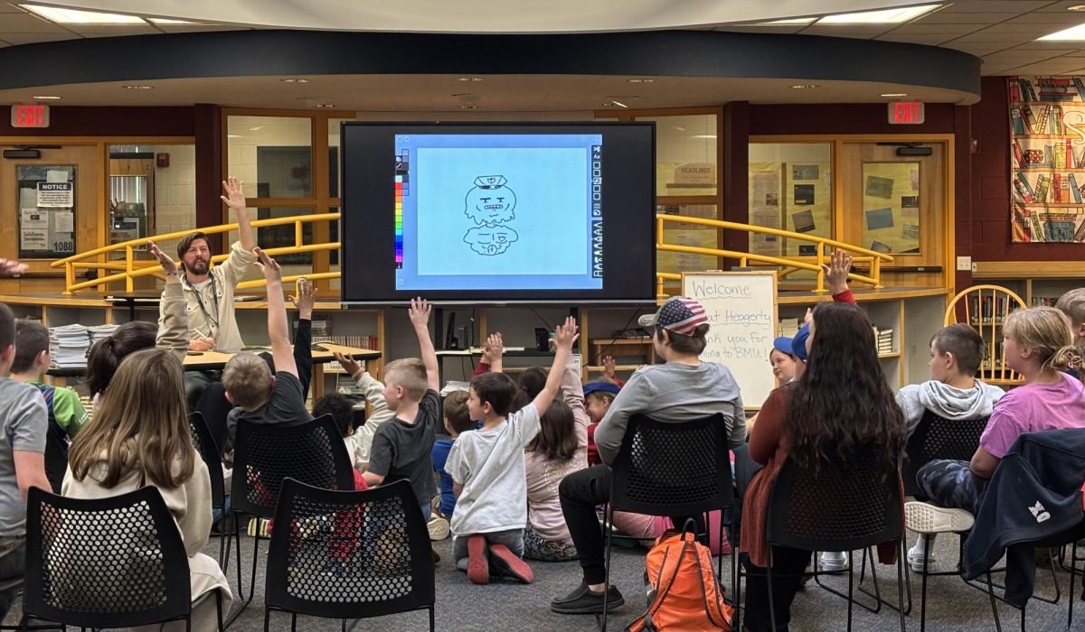 Author Mat Heagerty engaging with students and creating a drawing based on their ideas in BMU's Garvin Library on Friday, May 5, 2025. The interactive presentation teaches students about the importance of collaboration. 
