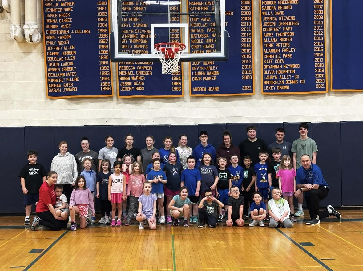 Blue Mountain K-2 smile with their high school coaches in the Dr. Harry M. Rowe Gymnasium on February 14, 2026. Students learn fundamentals and play games on the last Saturday morning basketball practice of the year.